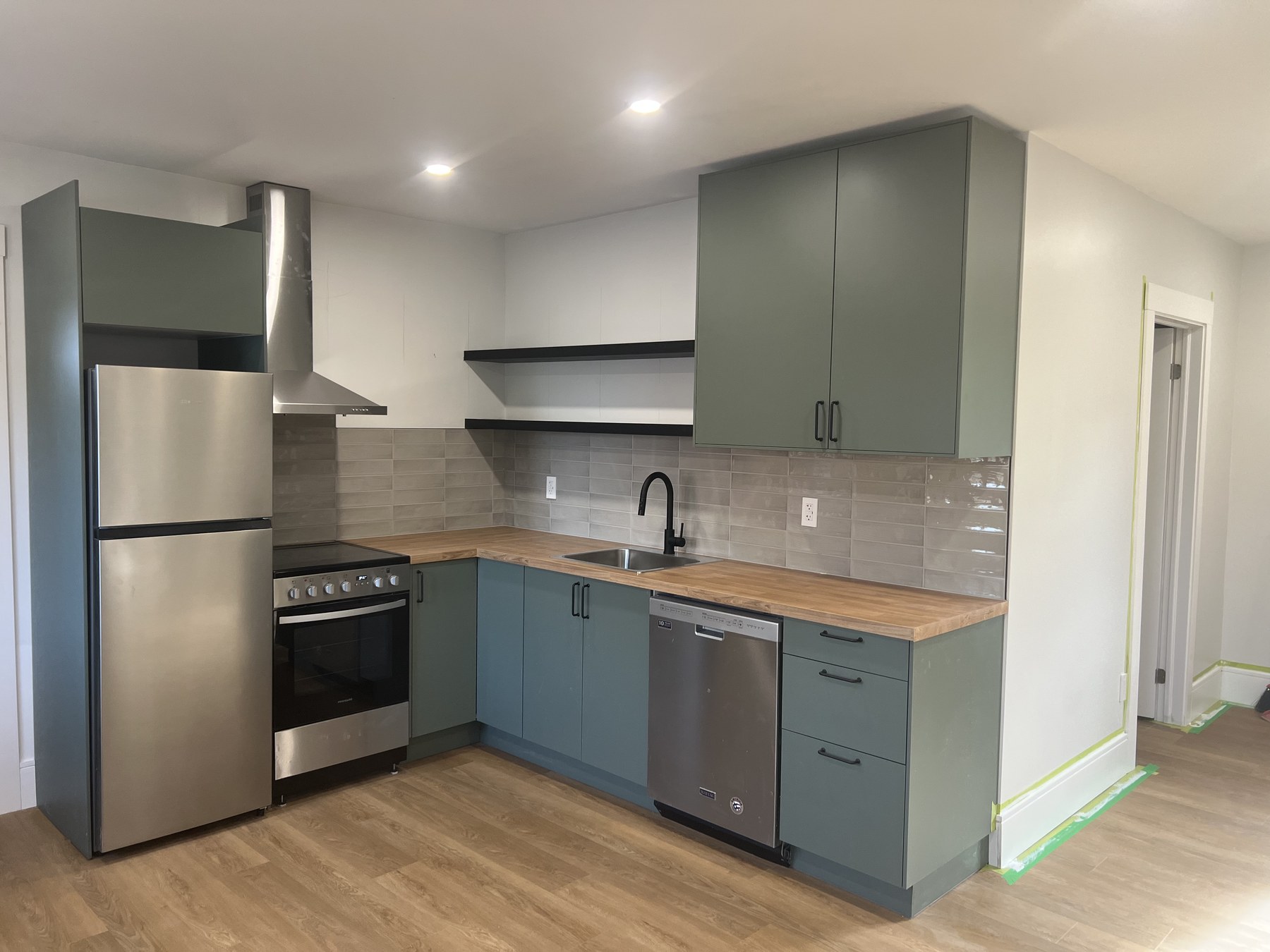 Modern kitchen with butcher block counters, stainless steel range, and dishwasher