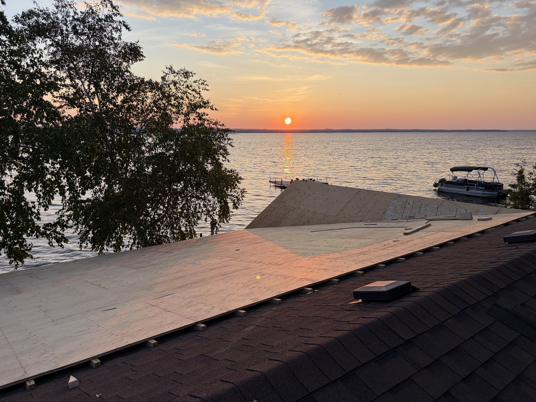 586 Lake Dr S - New roof sheathing at sunset over Cook's Bay