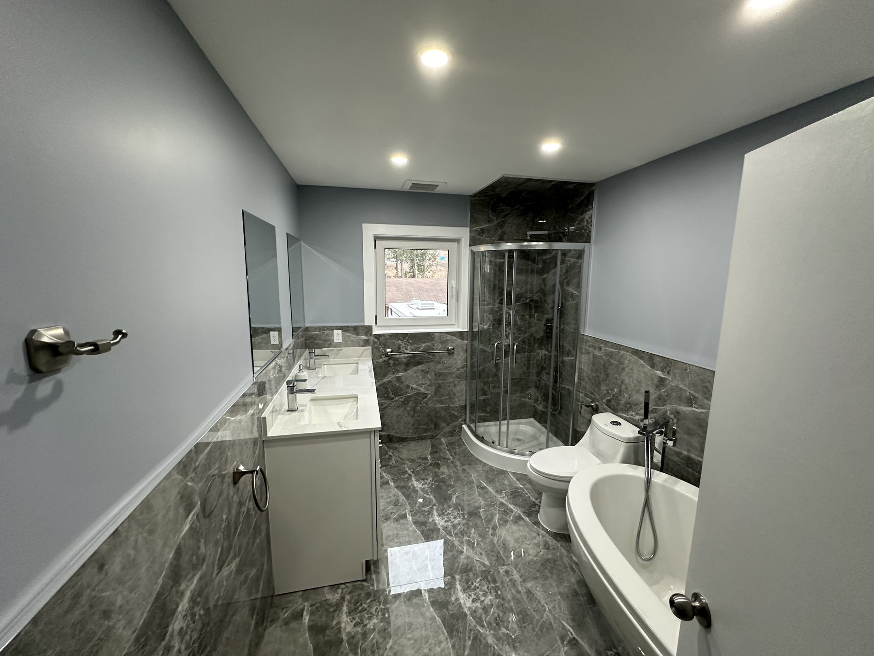 Four-piece bathroom with double vanity and glass shower