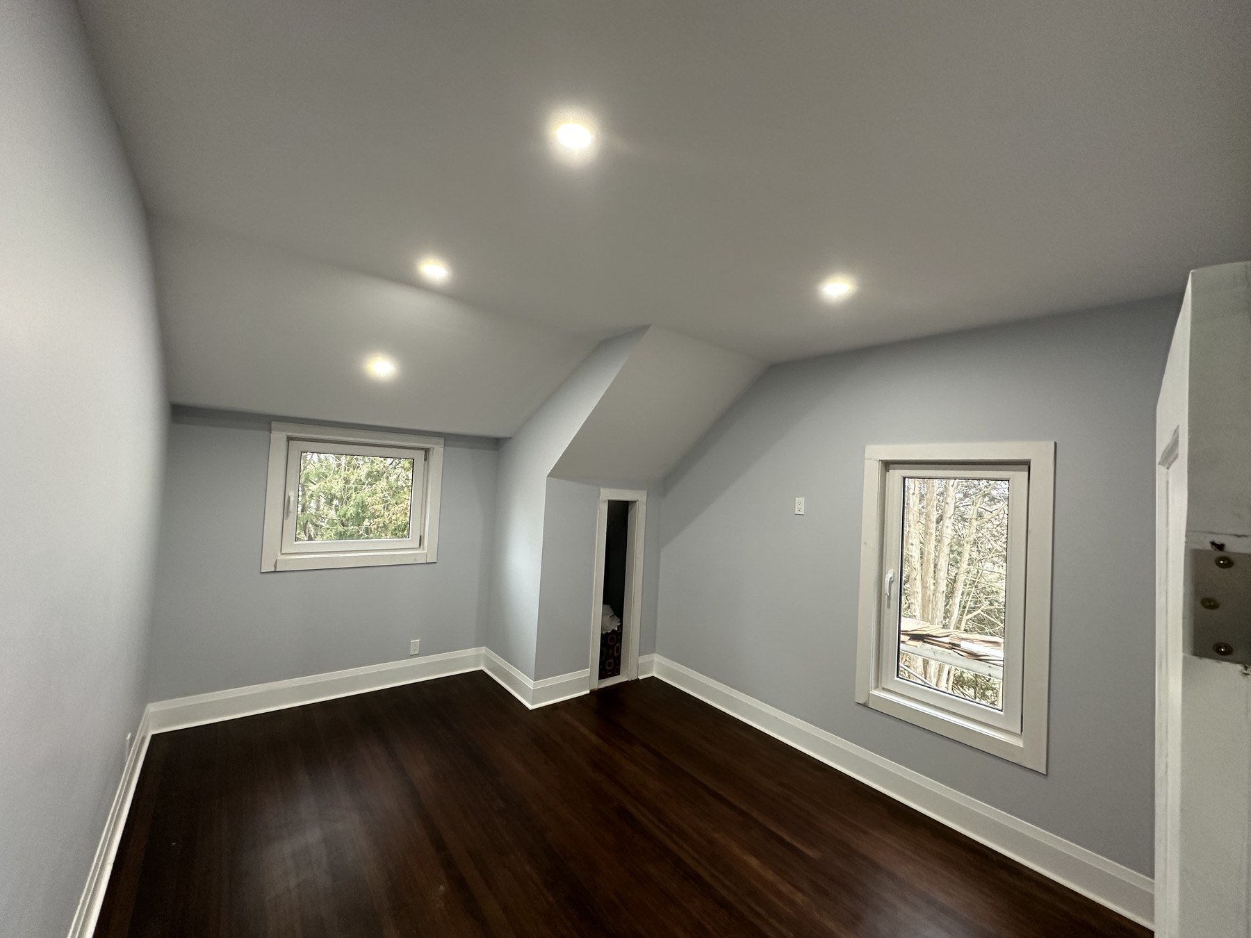 Bright bedroom with hardwood floors and large windows