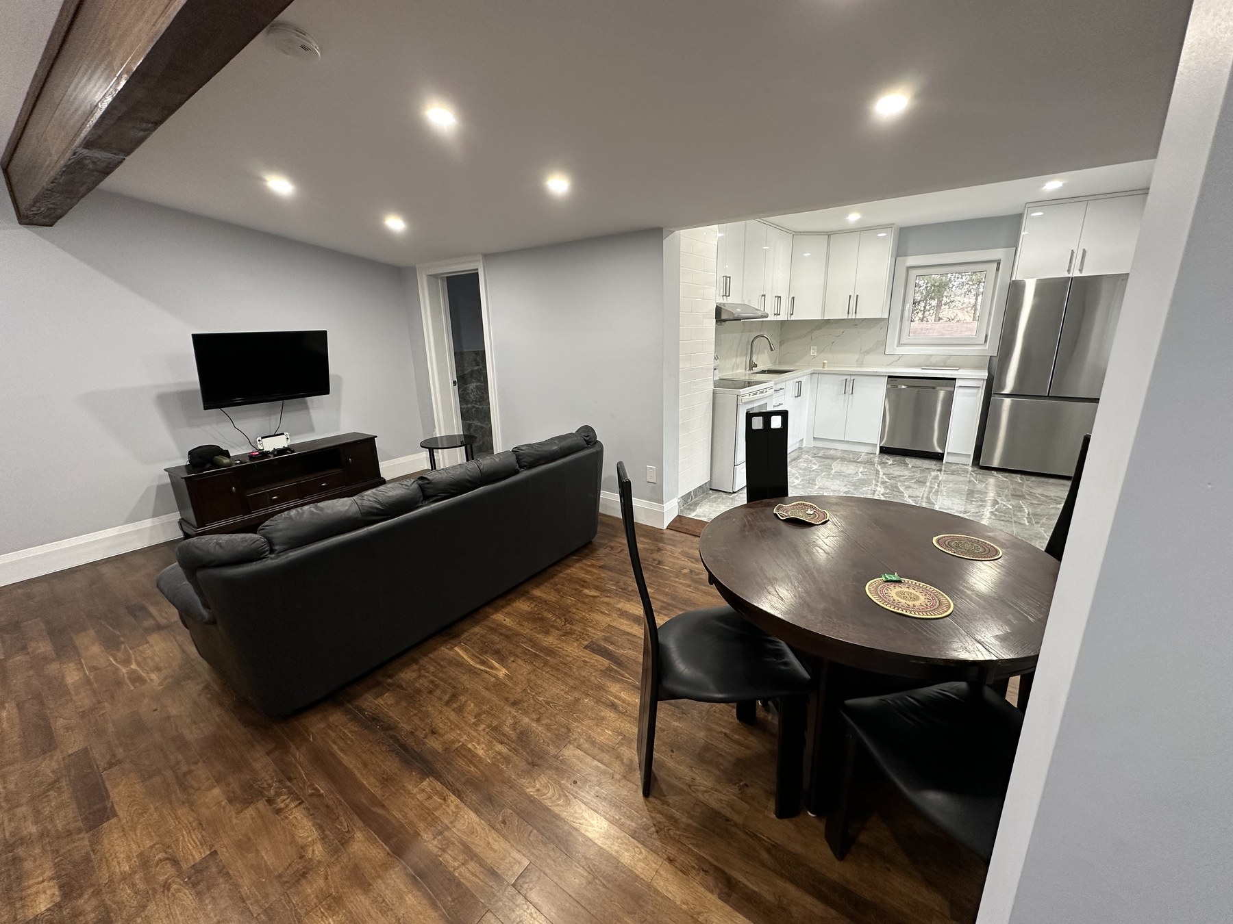 Open-concept kitchen with quartz backsplash and stainless appliances